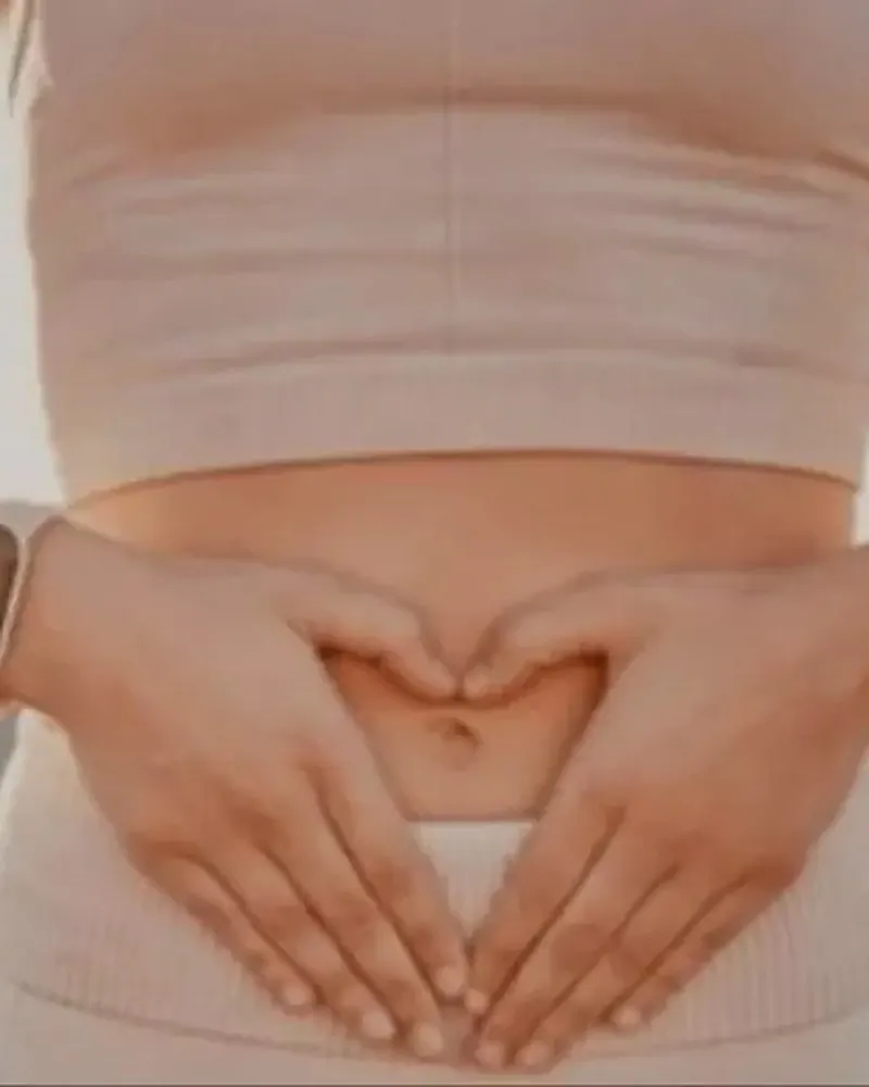 Mujer formando un corazón con las manos sobre el vientre, imagen del Rito del Útero